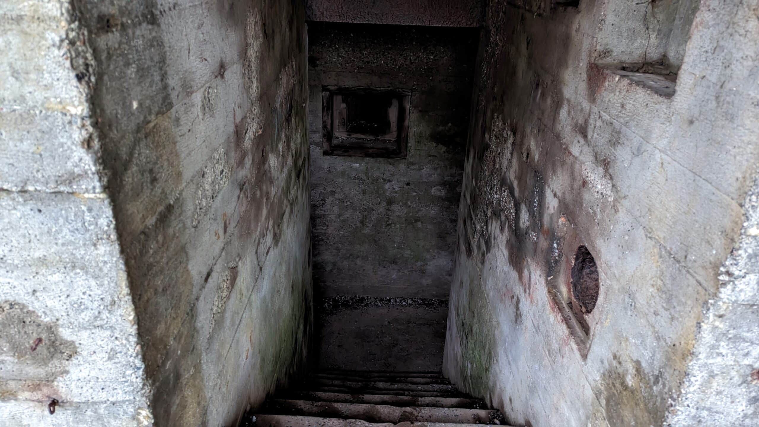 Eine Treppe, die zu einem Loch in einer Betonwand führt.