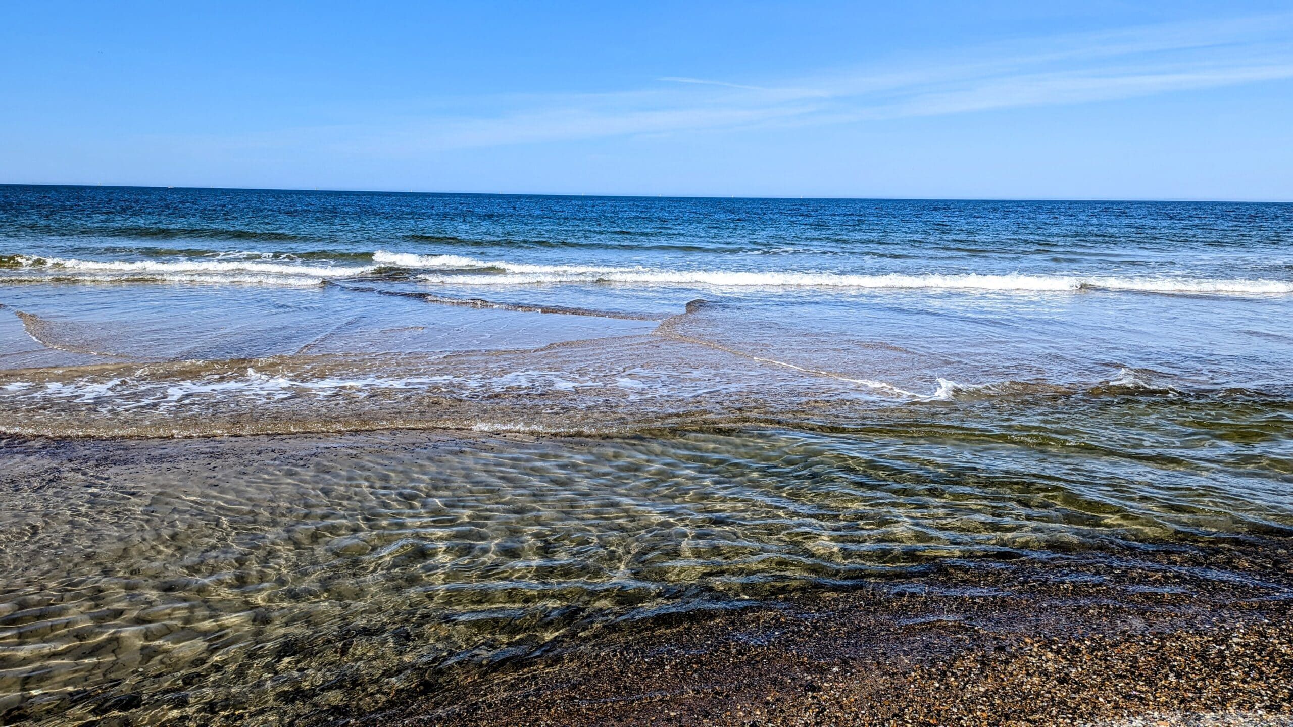 Ein Strand mit viel Wasser und Sand.
