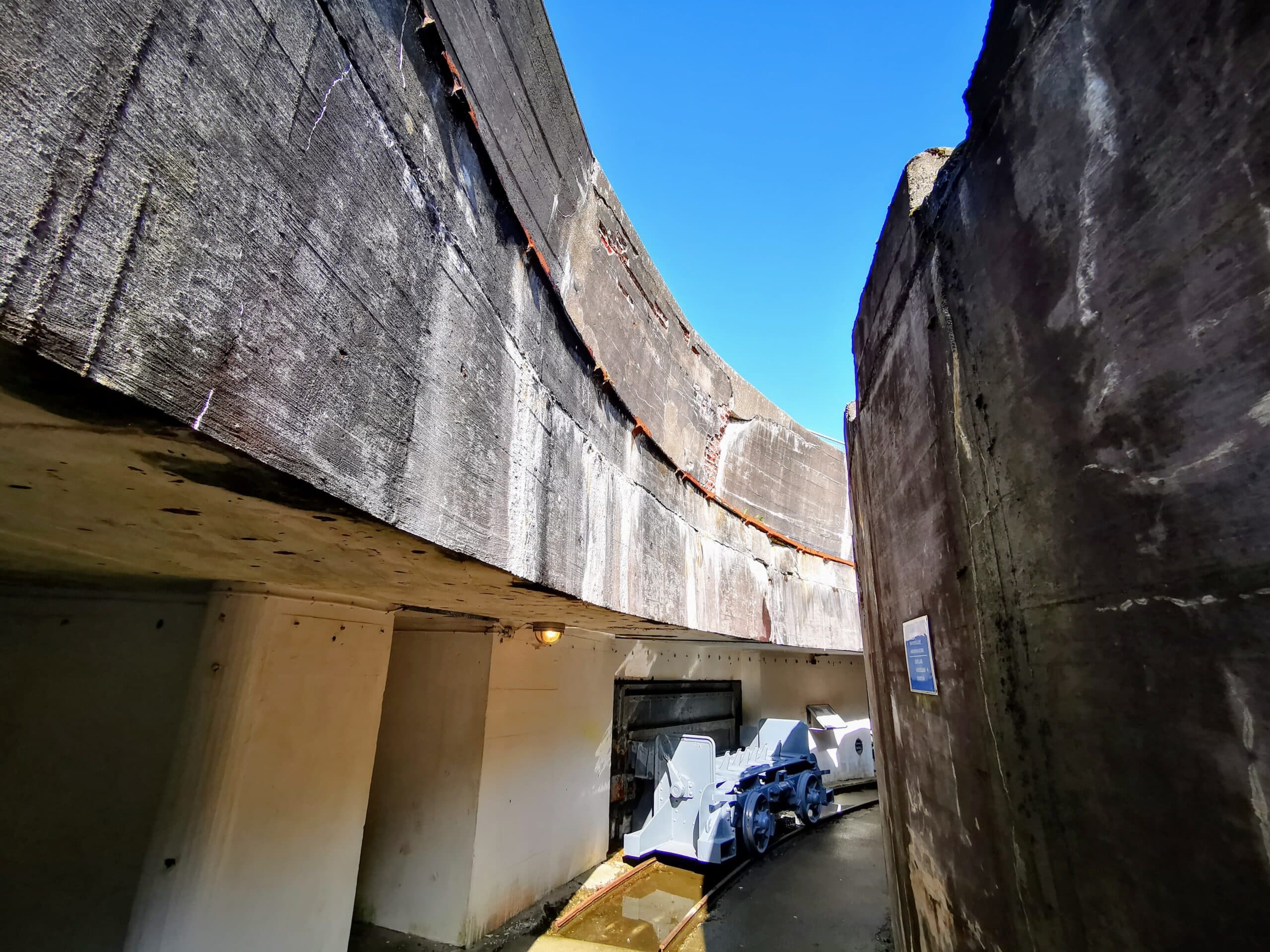 Ein Tunnel, der in ein Betongebäude mit blauem Himmel führt.