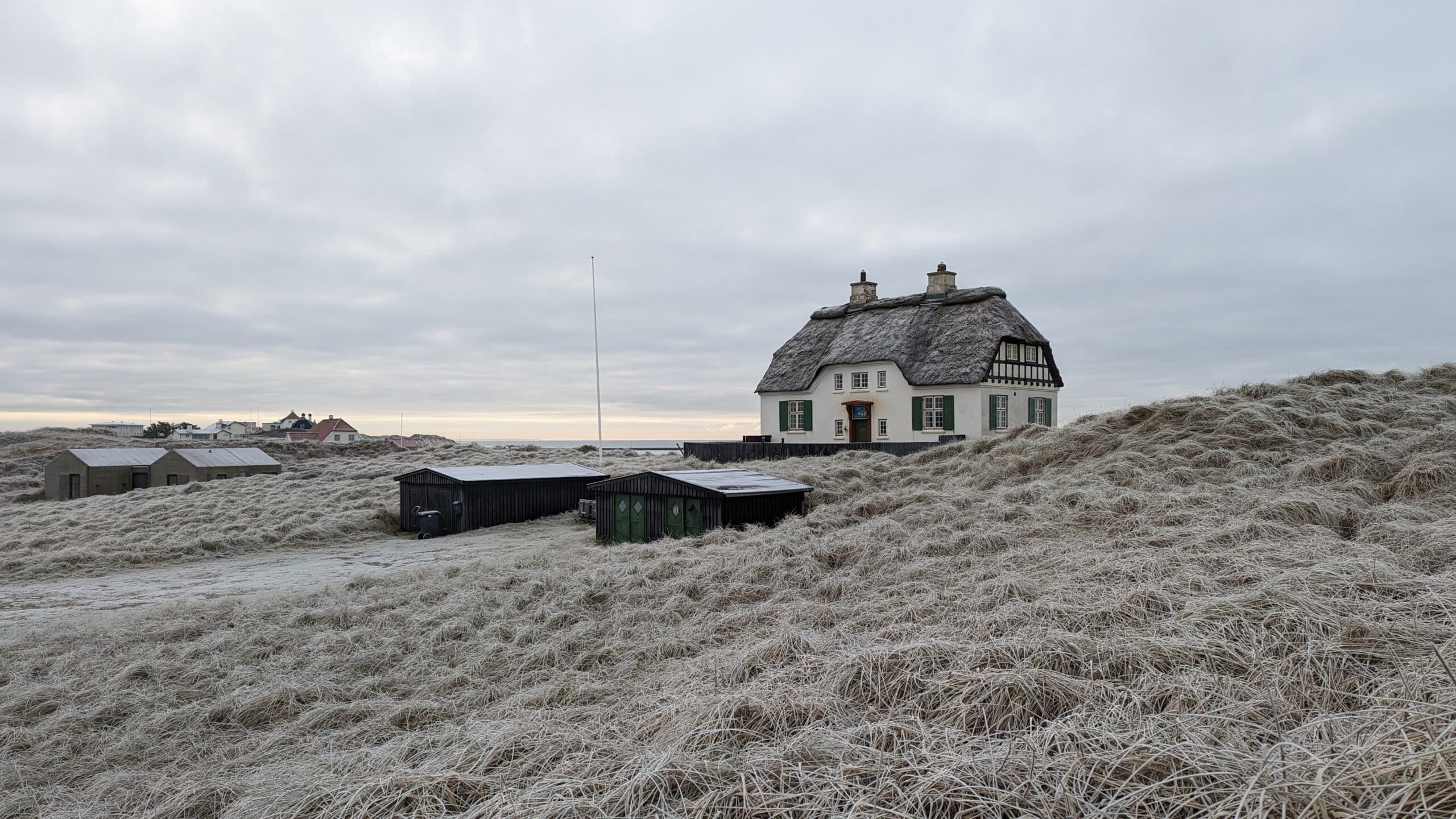 Ein Haus steht auf einem mit Frost bedeckten Hügel.