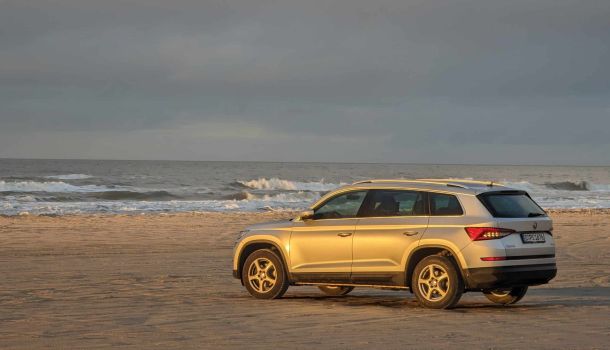 Ein Volkswagen Atlas parkte am Strand in der Nähe des Ozeans.