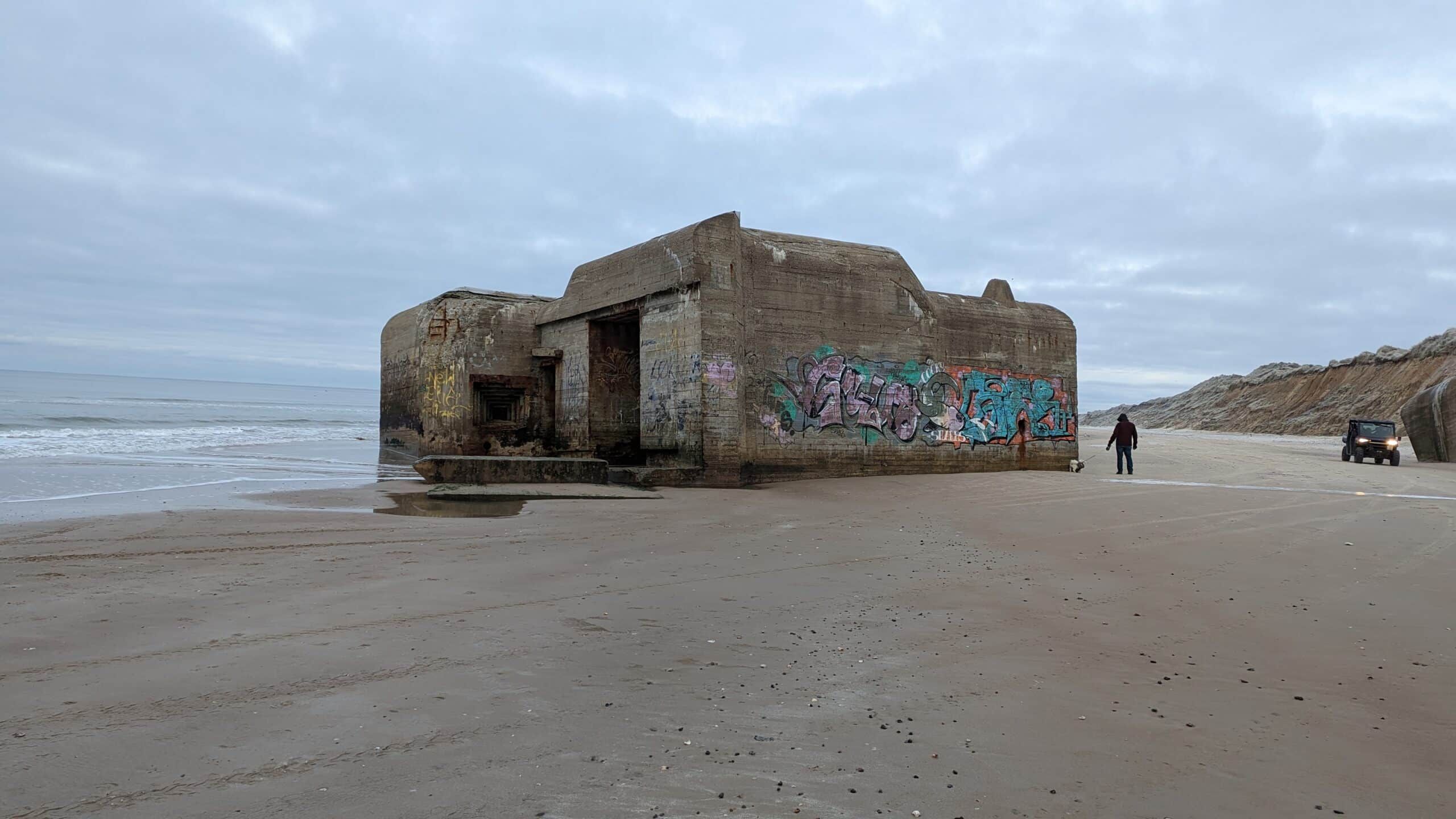 Ein Gebäude am Strand mit Graffiti darauf.