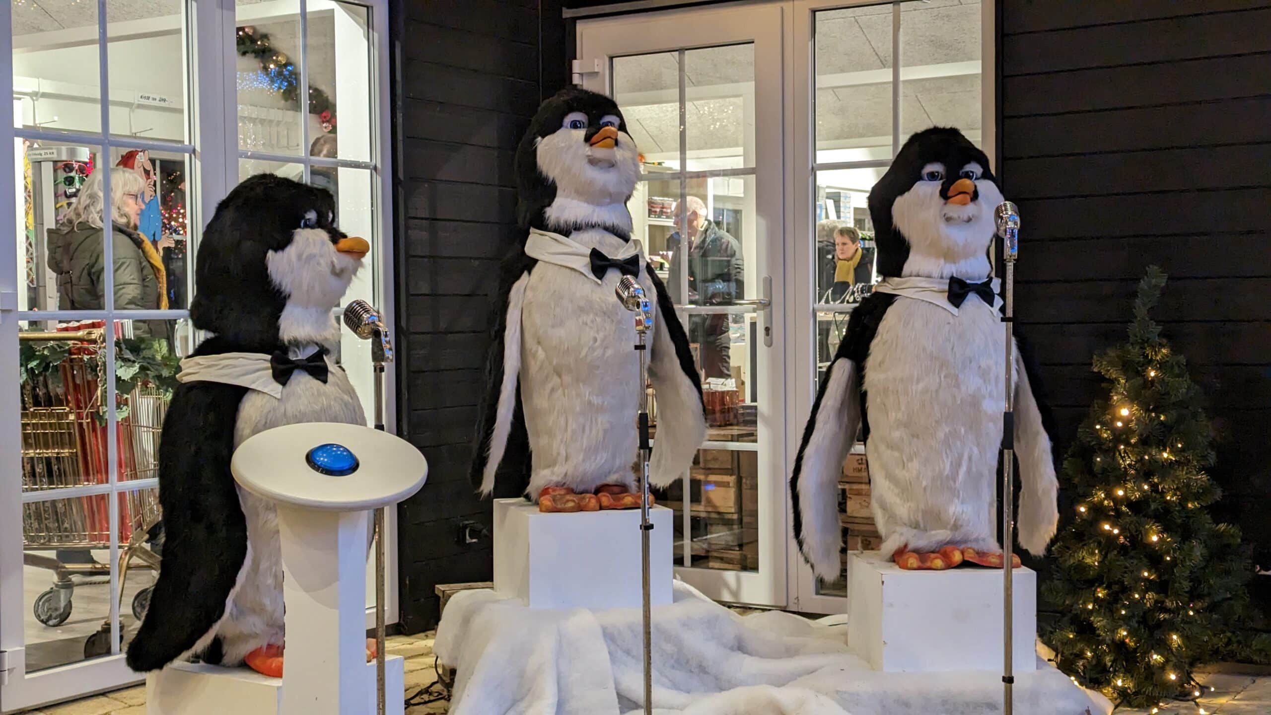 Eine Gruppe Pinguine vor einer Glastür.
