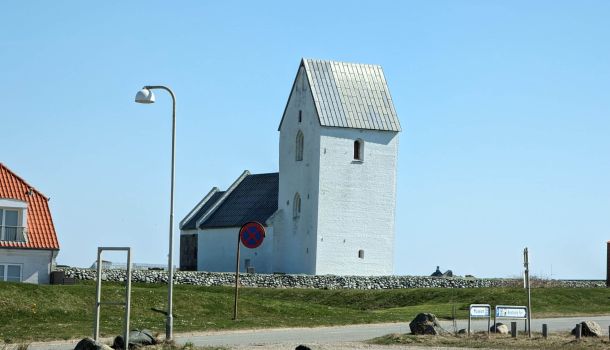 Eine weiße Kirche am Straßenrand.