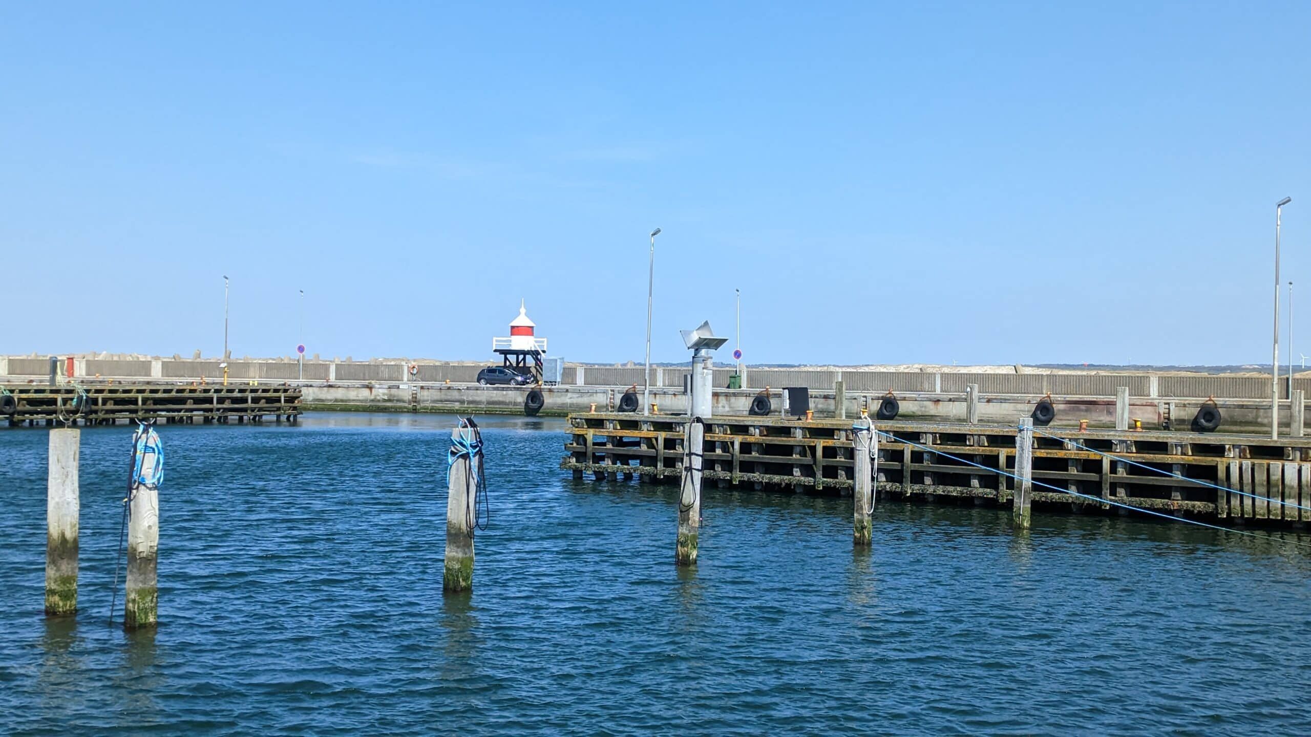 Ein Pier mit einem Leuchtturm mitten im Wasser.