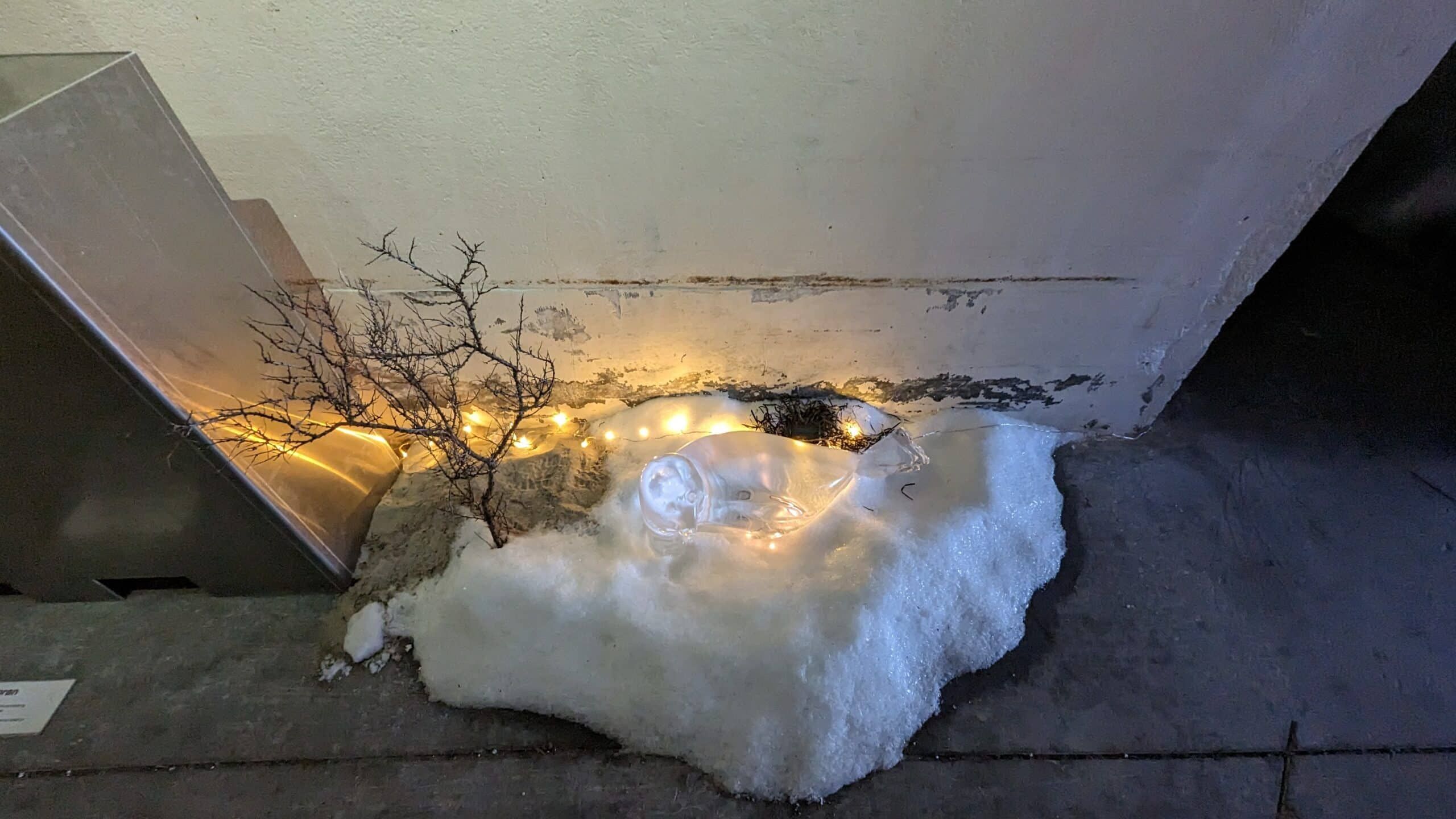 Ein Schnee und eine Glasflasche auf einem Betonboden.
