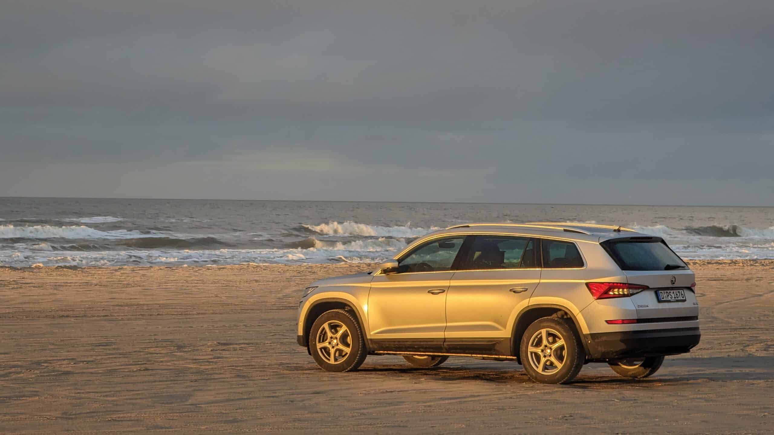Ein Volkswagen Atlas parkte am Strand in der Nähe des Ozeans.