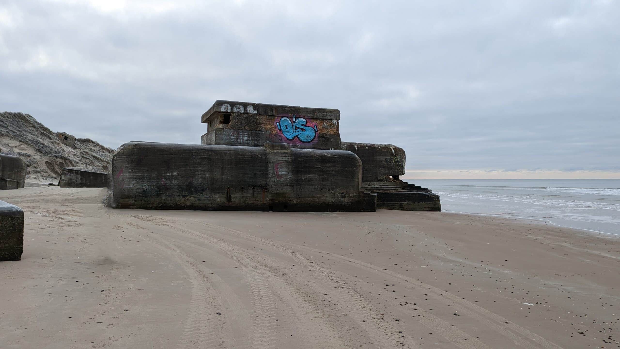 Ein Gebäude an einem Strand mit Graffiti darauf.