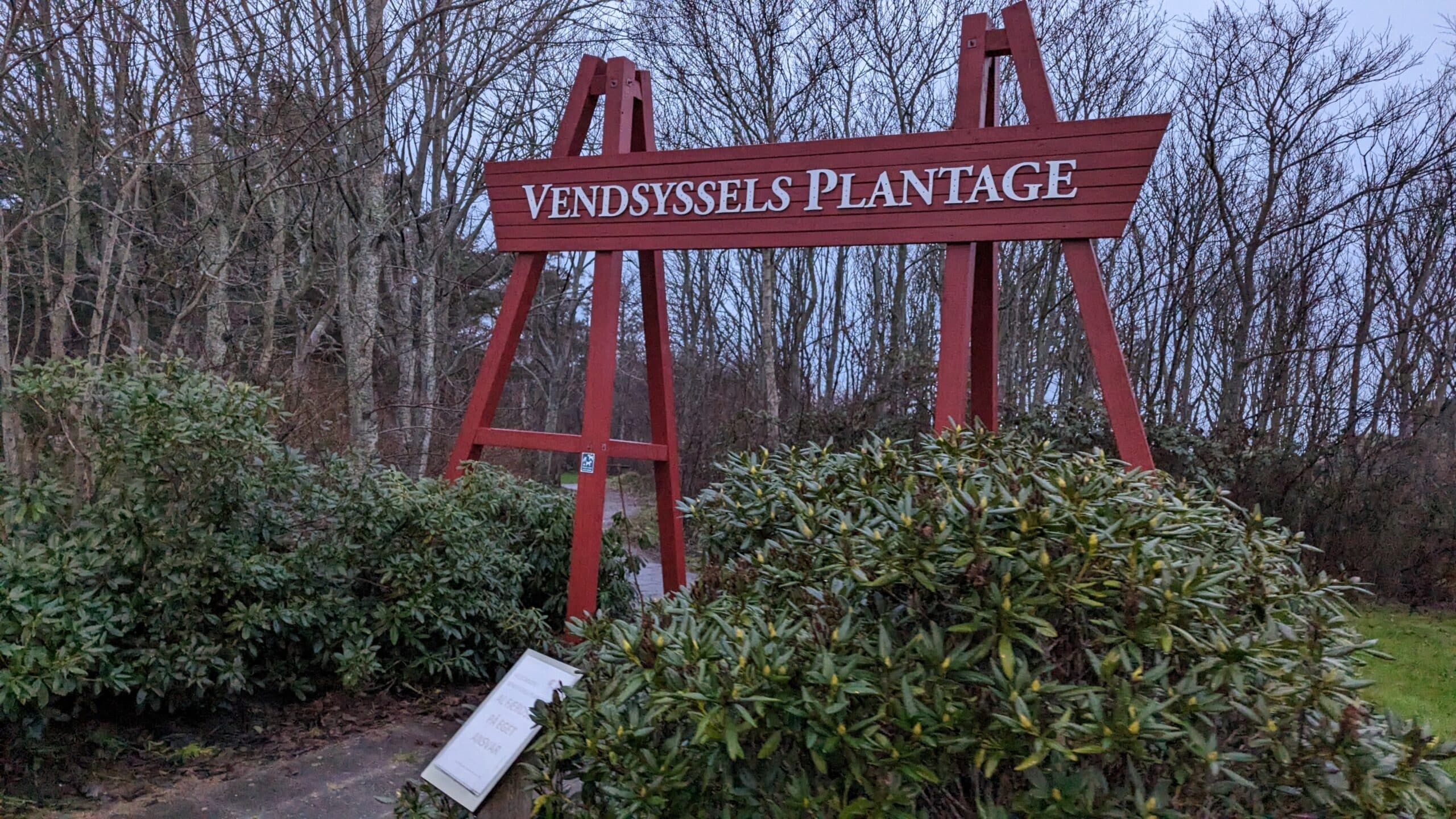 Ein Schild mit der Aufschrift Windsor's Plantage vor Büschen.