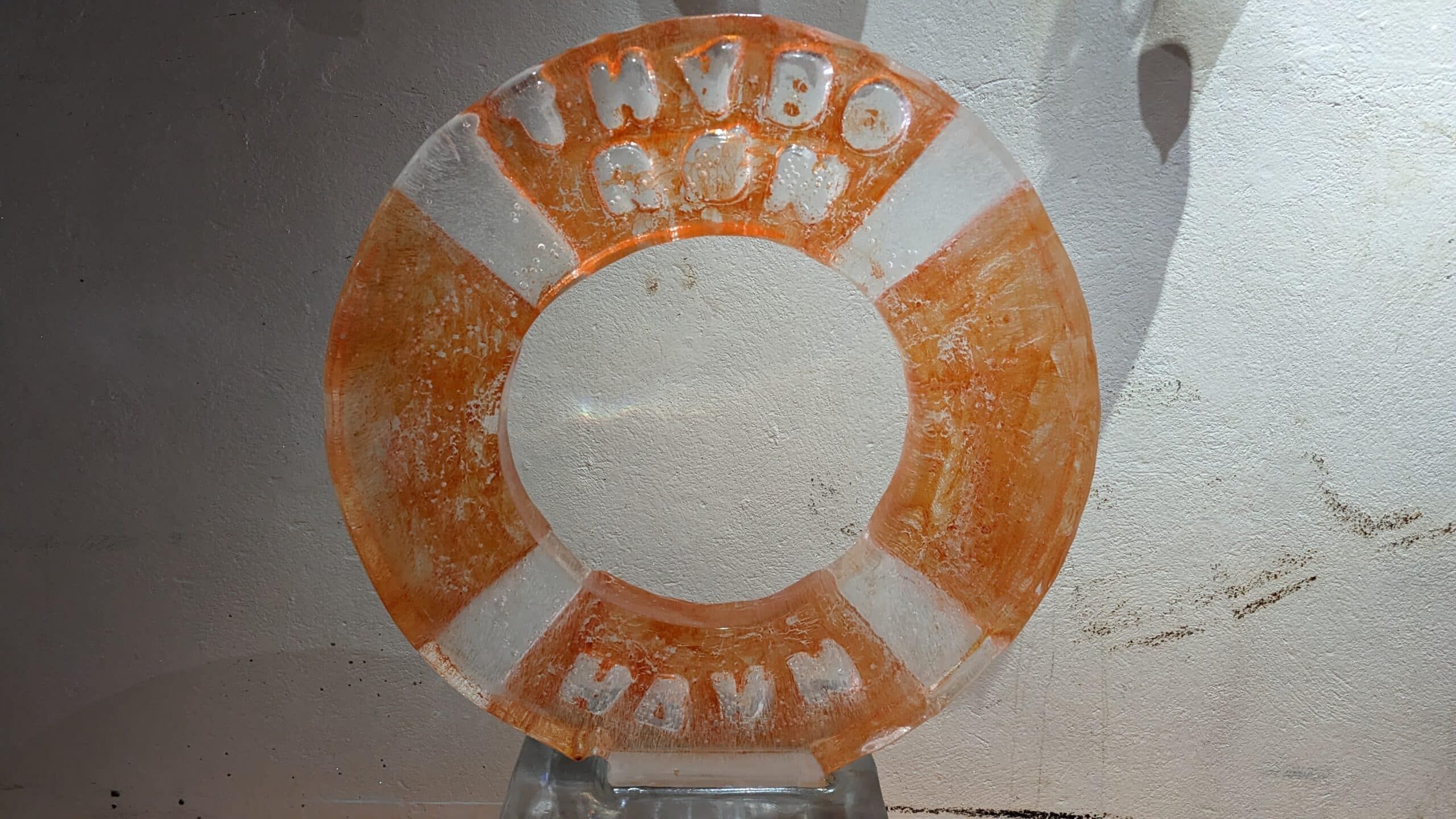 Ein orangefarbener Rettungsring auf einem Tisch mit weißem Hintergrund.
