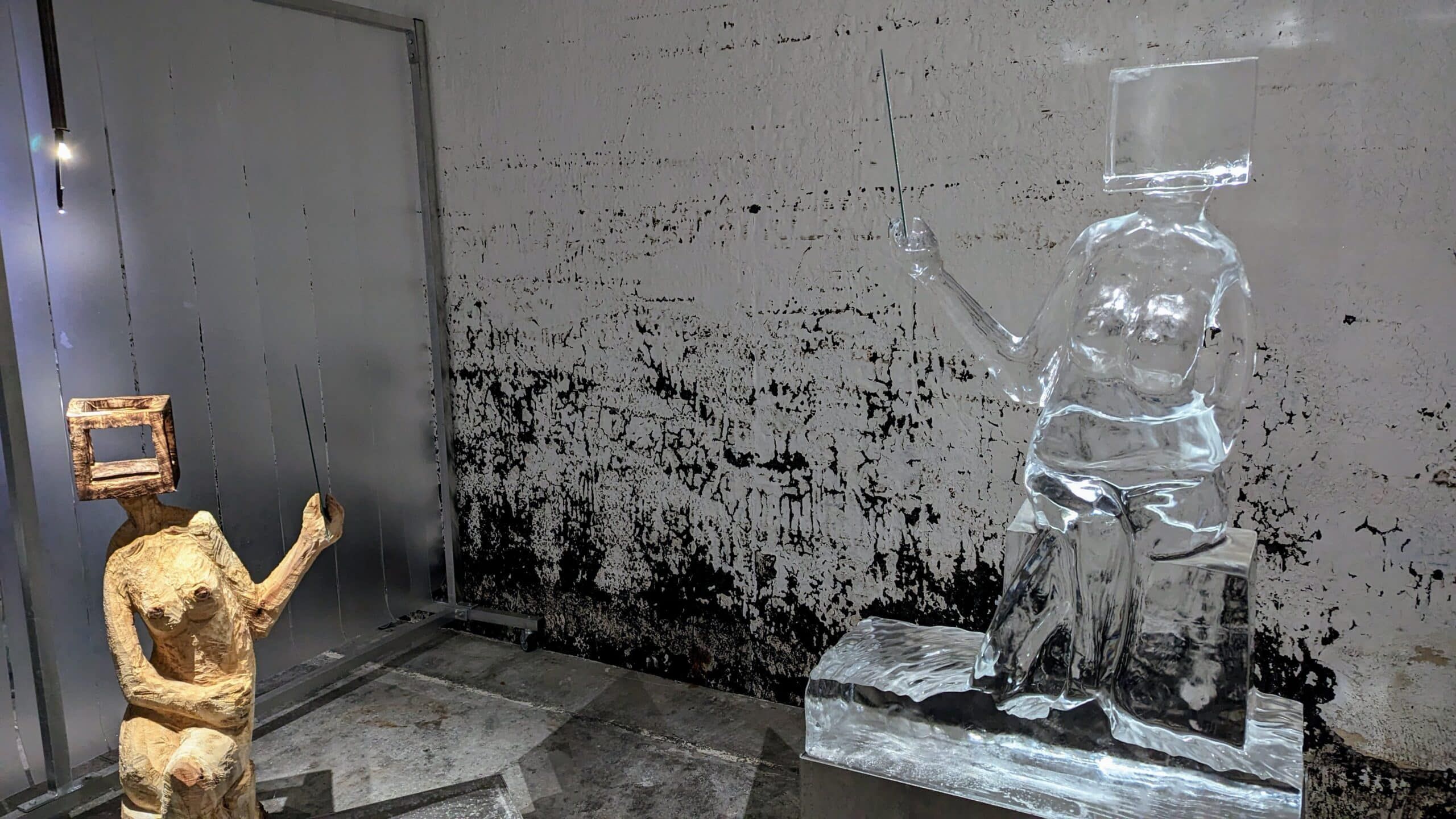 Eine Glasskulptur einer Person, die einen Stock hält.