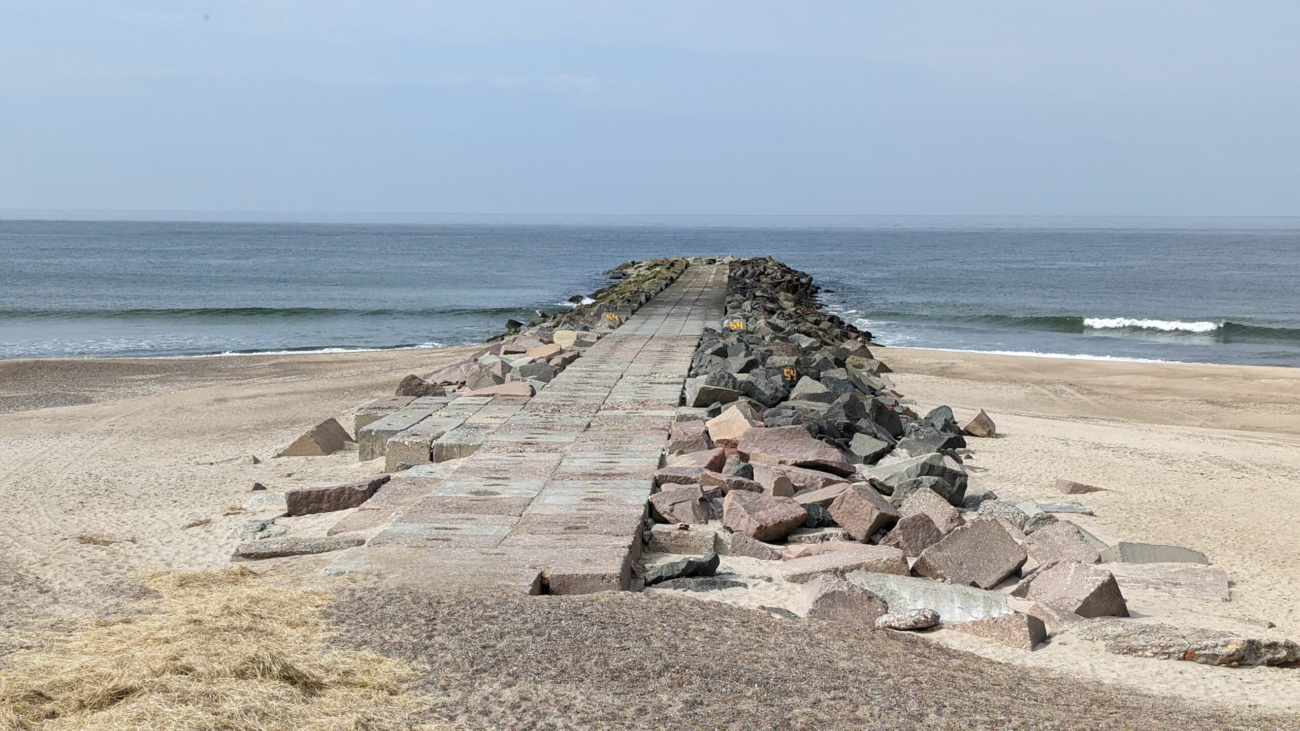 Ein Strand mit Felsen und Sand neben dem Meer.