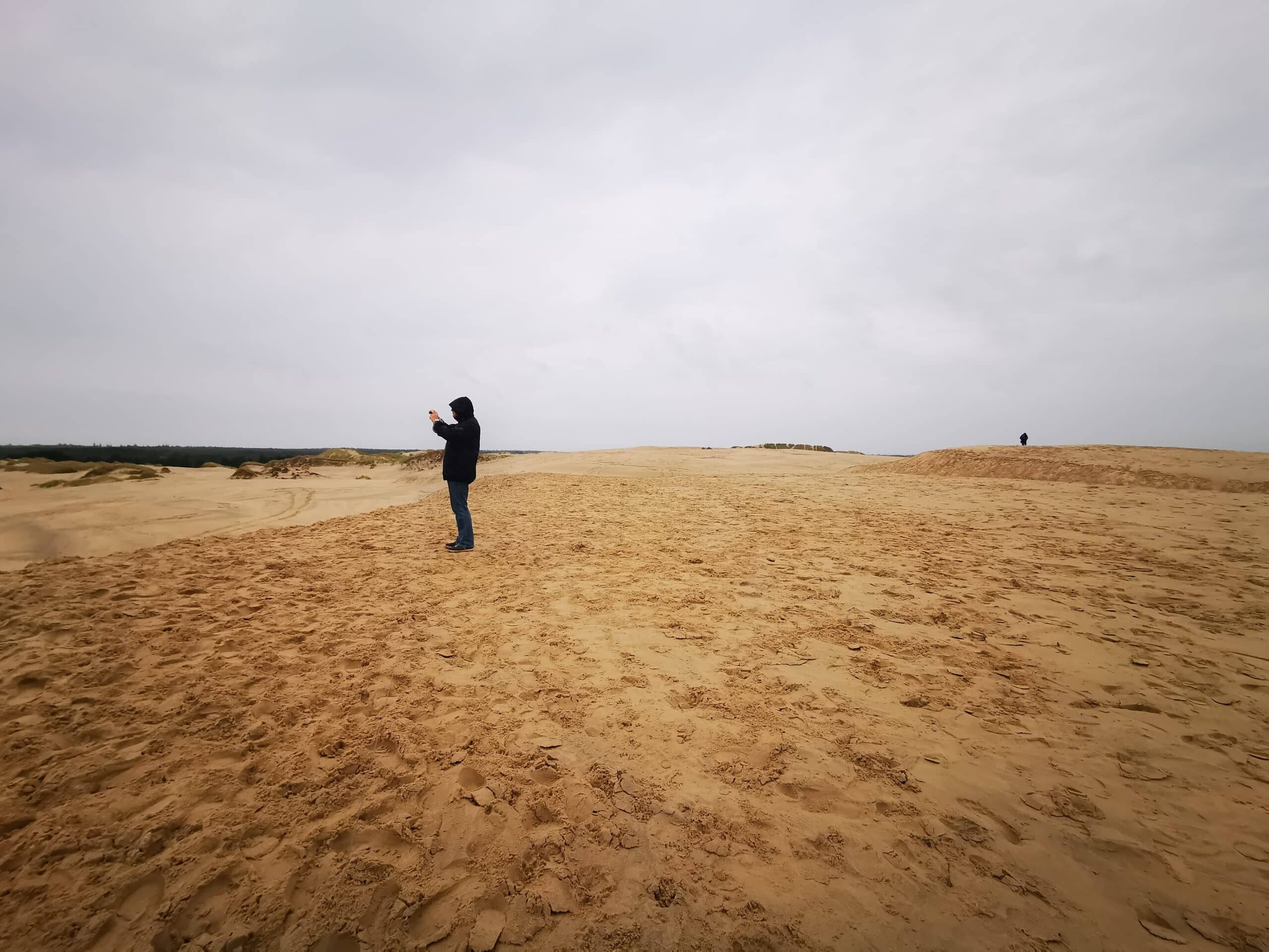 Eine Person steht auf einer Sanddüne.