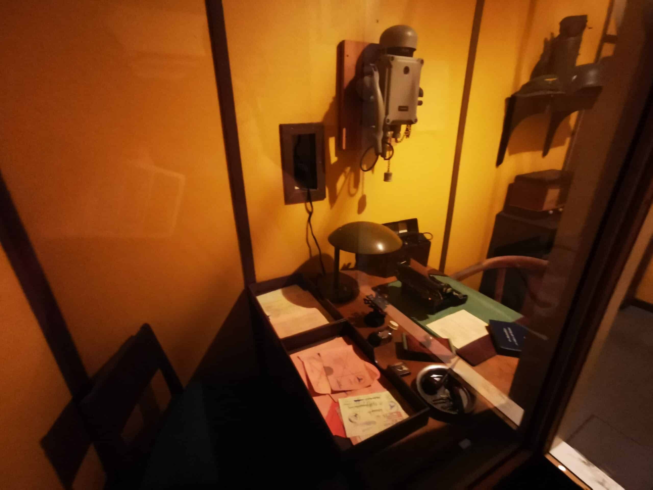 Ein kleines Zimmer mit Schreibtisch und Telefon.