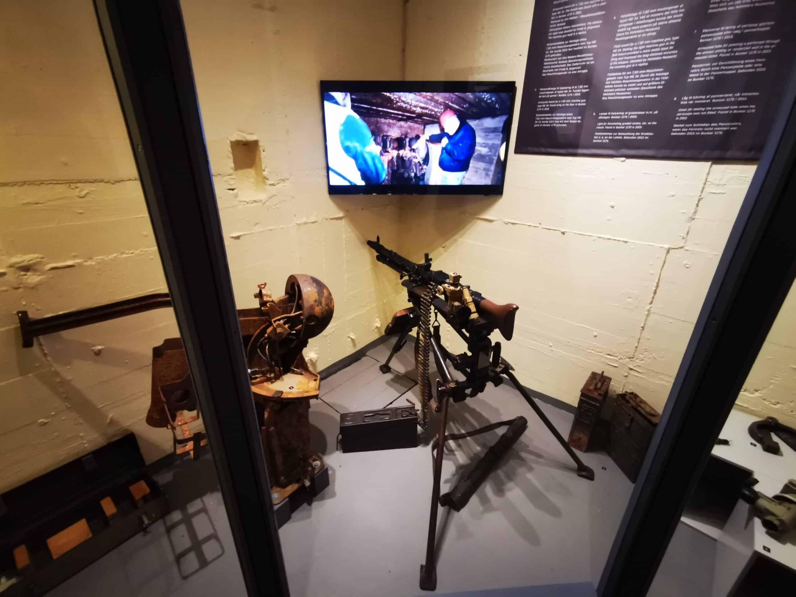 Ein Raum mit einem Fernseher und einer ausgestellten Waffe.