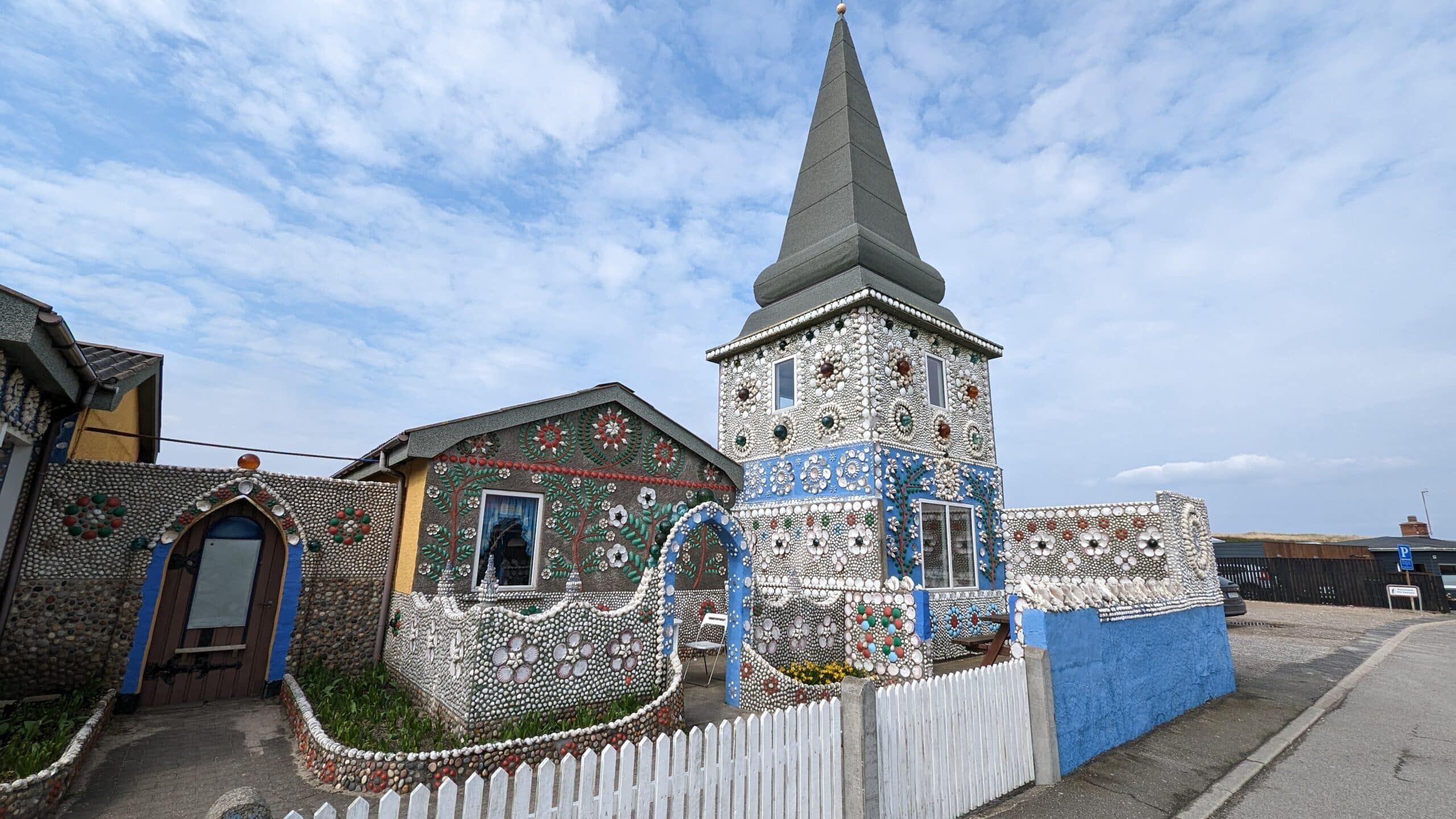 Eine Kirche mit einem Kirchturm in der Mitte einer Straße.