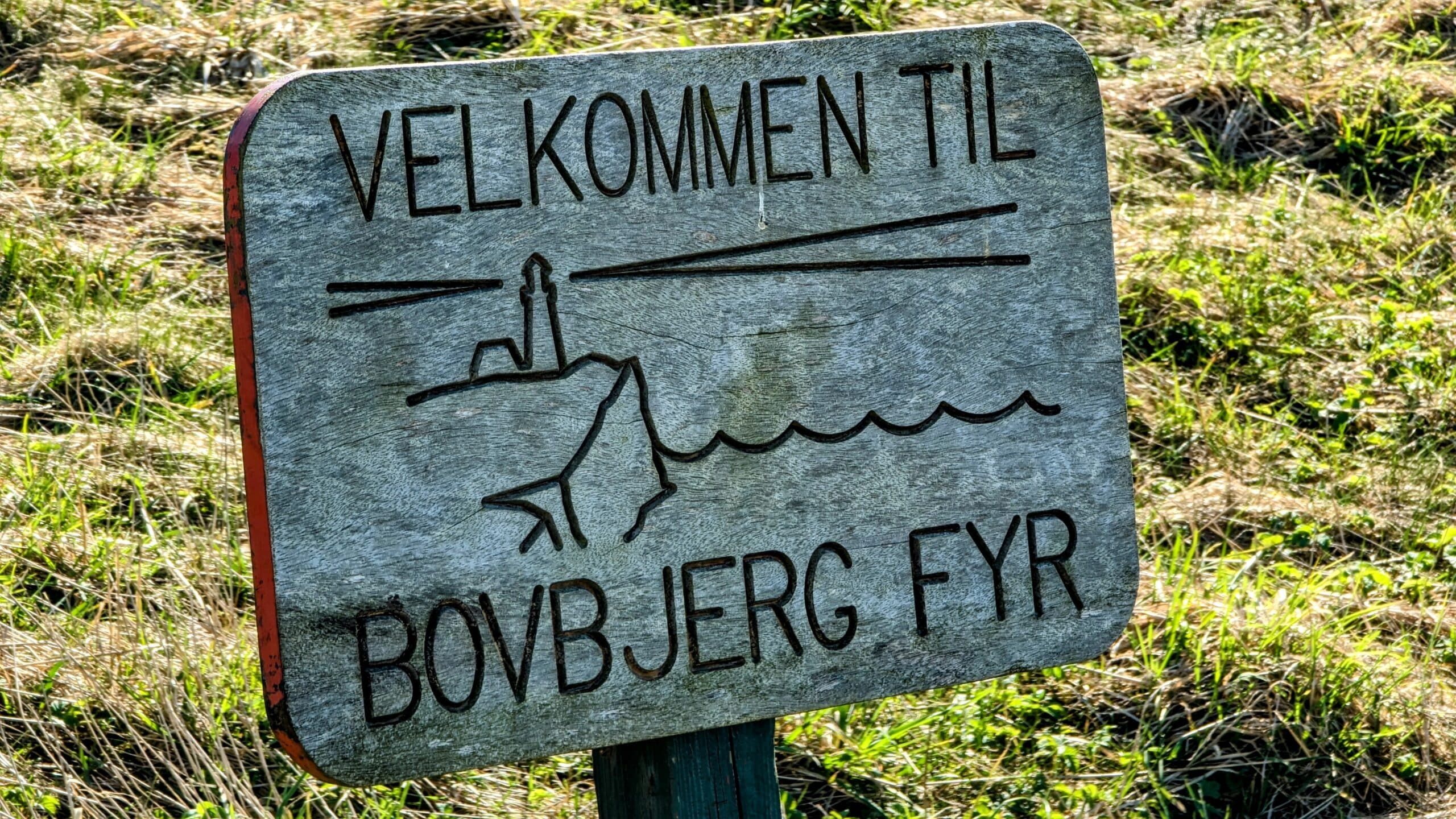 Ein Schild auf einer Wiese mit der Aufschrift „Velkommet ti bojjerf fyr“.