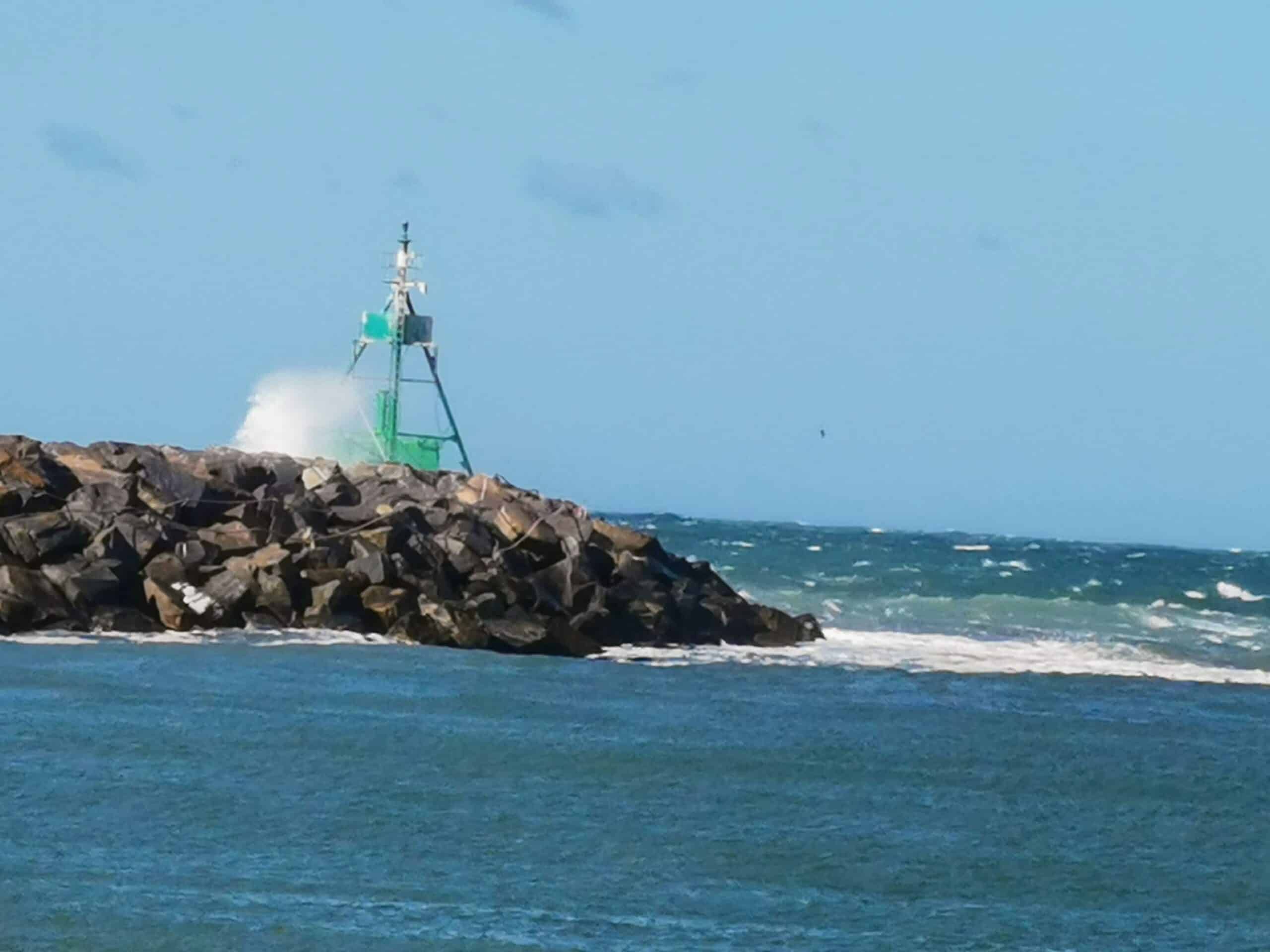 Ein Leuchtturm auf einem Felsen im Meer.