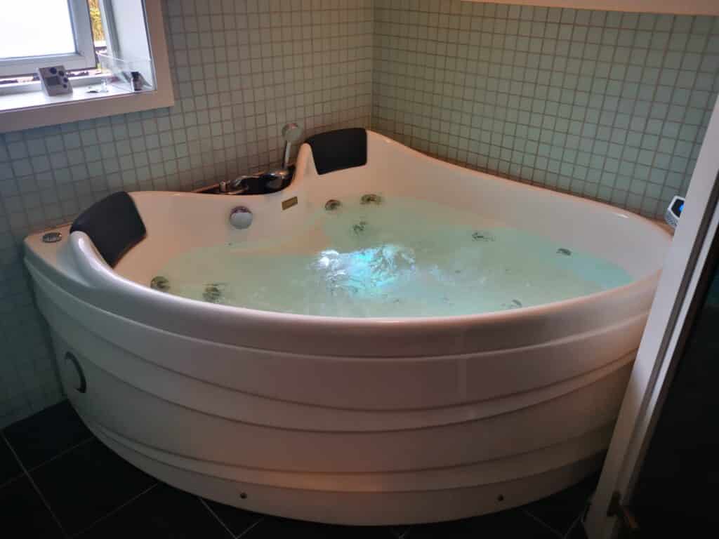 Eine weiße Whirlpool-Badewanne im Badezimmer.